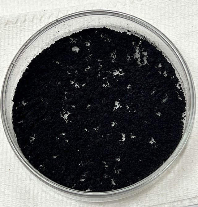 Black charcoal powder in a glass petri dish before plasma ashing